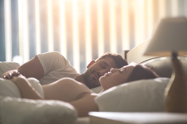 The man sleeping near a woman in the comfortable bed