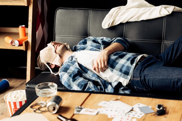 写真 パーティーの後、ブラジャーを顔につけてソファで寝ている男性
