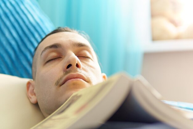 Man sleeping with the book on the sofa close up Selective focus