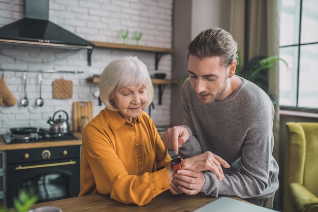 Man smartwatch aan de hand van zijn moeder te bevestigen