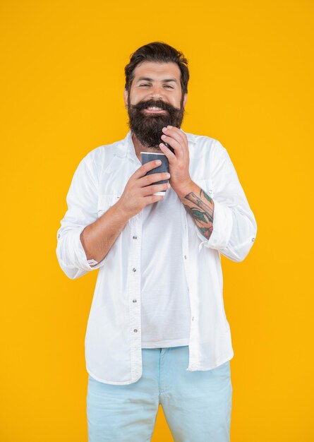 Man smelling coffee at break on background photo of man has coffee break man has coffee break isolated on yellow man has coffee break in studio