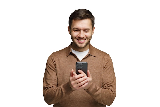 man smiles while using smartphone in a cozy indoor setting during daytime