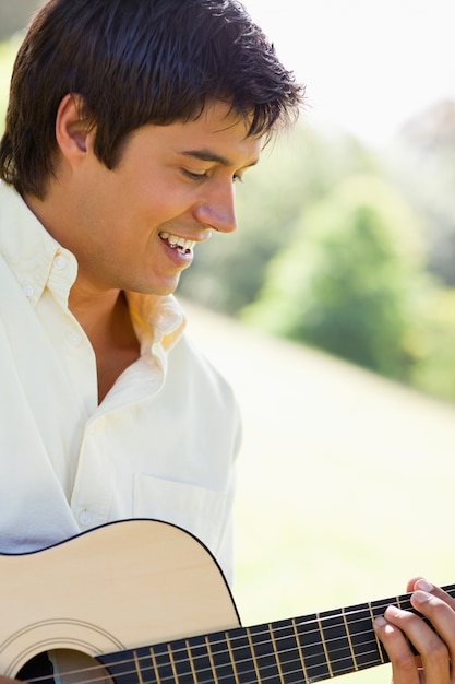 L'uomo sorride mentre suona una chitarra