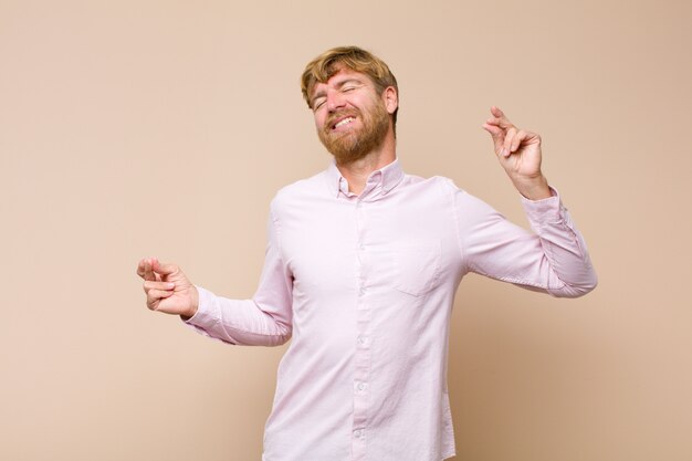 Man smiling, feeling carefree, relaxed and happy, dancing and listening to music, having fun at a party