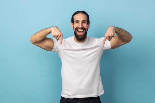 Man smiling and pointing down showing place for idea presentation commercial text