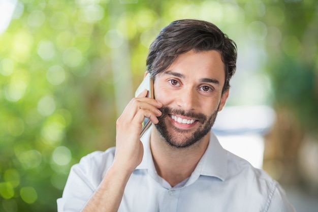 彼の携帯電話で話しながら笑っている男