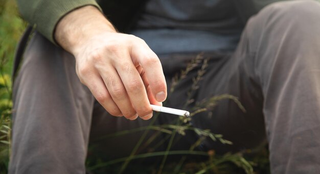 Мужчина курит сигарету на открытом воздухе Концепция курения