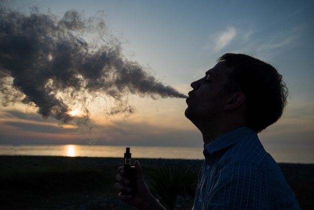 Equipaggi il modo vaping della scatola del vape della sigaretta elettronica vaping sopra il tramonto dorato