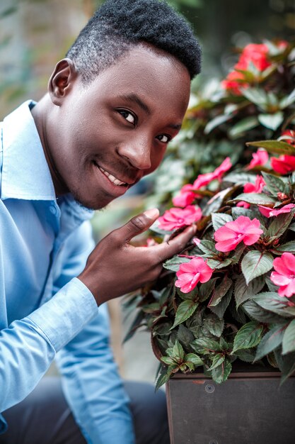 man  sniffing the flowers