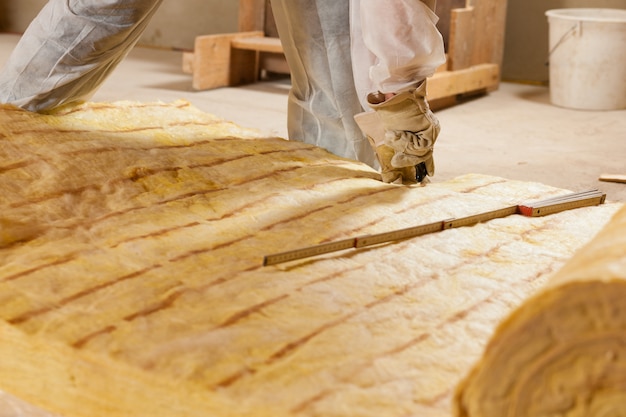 Man snijden isolatiemateriaal voor de bouw