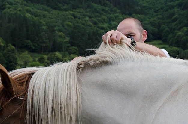 Man snijden paardenhaar met een schaar