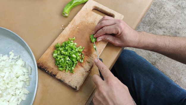 Man snijdt groenten op snijplank voor picknick, handen close-up