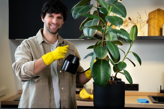 Man snijdt zieke bladeren van een huisplant met een schaar