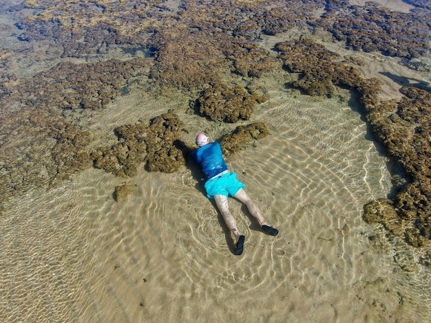 Man snorkelen in koraalrif in tropische transparante zee