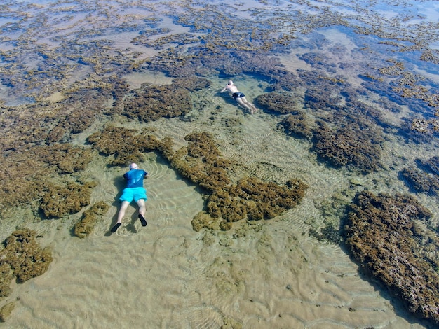 Man snorkelen in koraalrif in tropische transparante zee