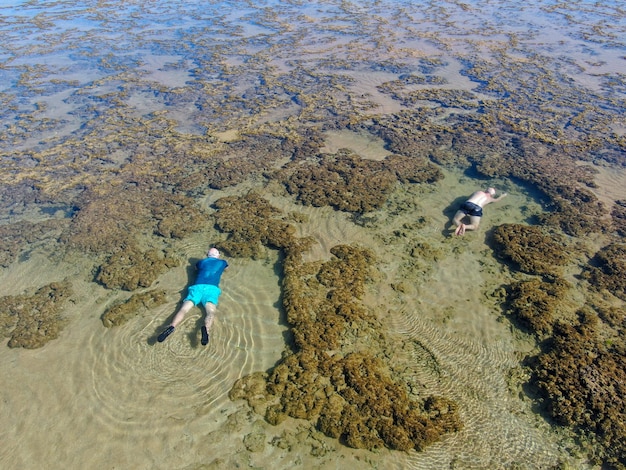 Man snorkelen in koraalrif in tropische transparante zee