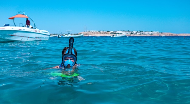 man in a snorkeling mask dives into the sea