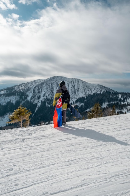 Man snowboarder met vlag van Slowakije op de helling van het skioord