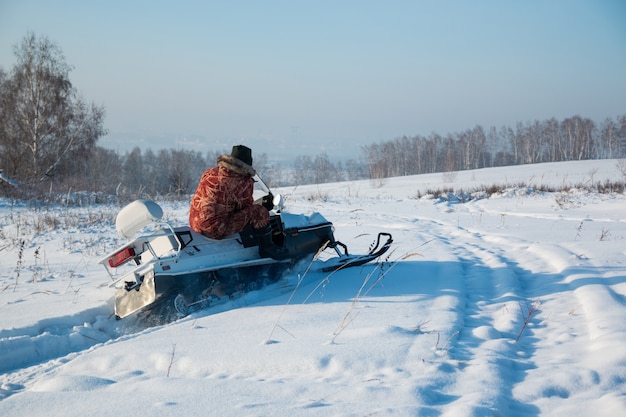 Man on snowmobile in winter, Siberia