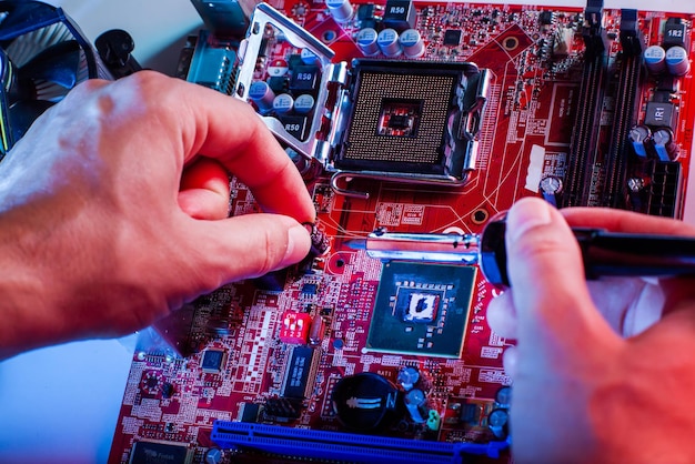 A man soldering a motherboard Repair and maintenance of desktop personal computers and laptops