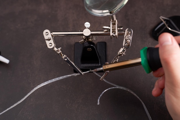 Photo man soldering two small wires.