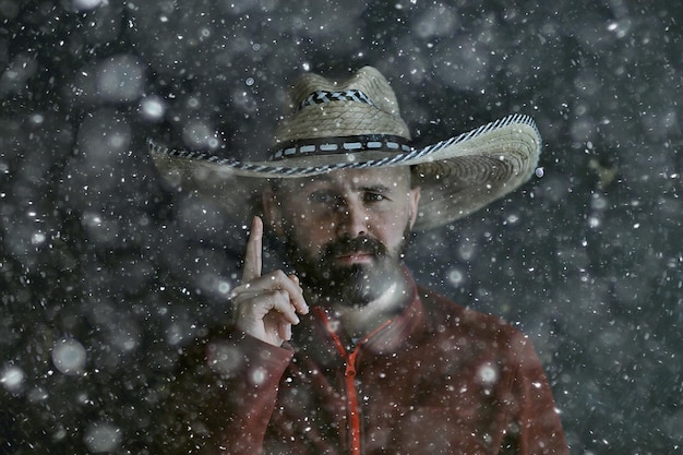 つば、メキシコスタイル、ラテンアメリカ、雪の寒い冬のクリスマスの背景を持つソンブレロ帽子の男