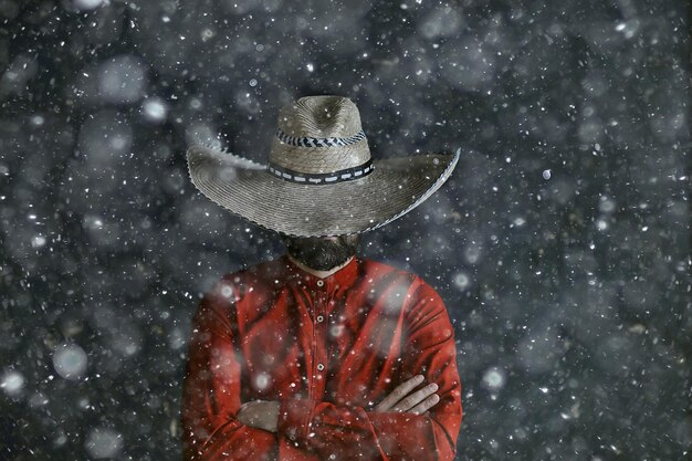 つば、メキシコスタイル、ラテンアメリカ、雪の寒い冬のクリスマスの背景を持つソンブレロ帽子の男