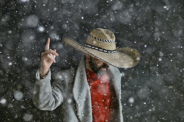 つば、メキシコスタイル、ラテンアメリカ、雪の寒い冬のクリスマスの背景を持つソンブレロ帽子の男