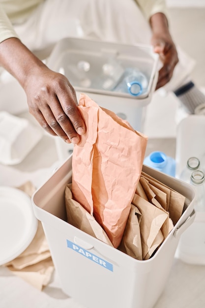 Man sorteert papier en plastic in containers