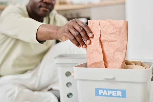 Man sorteert papier in container