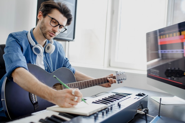 Man speelt gitaar en produceert elektronische soundtrack