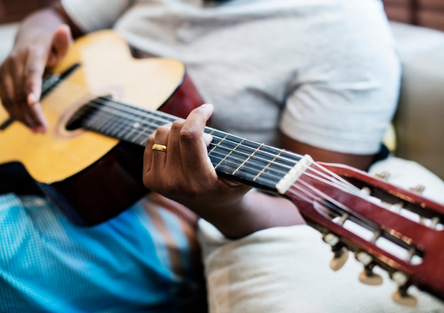 Man speelt op zijn gitaar