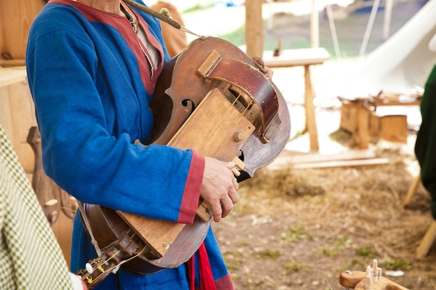 Man spelen van het oude snaarinstrument, wederopbouw van de oudheid