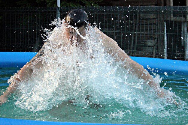 写真 ウォーディングプールで水をスプラッシュする男性