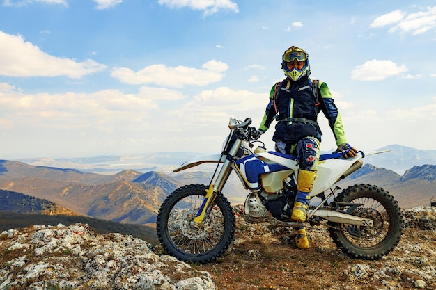 山でモトクロスバイクに乗るスポーツ用品の男