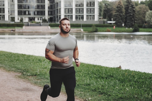 Photo man sportsman runner running in park training and exercising