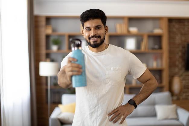 Foto uomo in abbigliamento sportivo che tiene una bottiglia d'acqua e sorridente