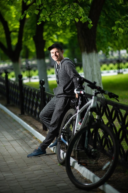 Photo a man in sportswear with a bicycle on a city alley