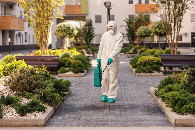 Man spraying outdoors in order to prevent coronavirus form spreading