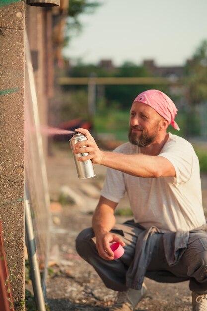 Foto uomo che spruzza vernice sul muro