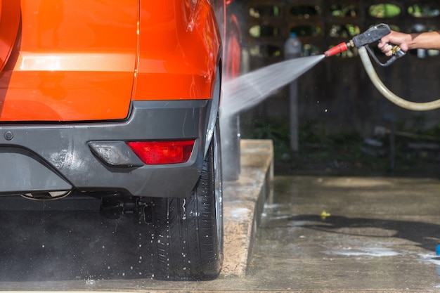 A man spraying pressure washer for car wash in car care shop