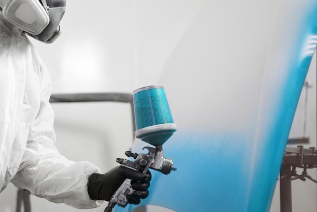 Man sprays blue dye on the elements of the vehicle Recovery of the car after the accident