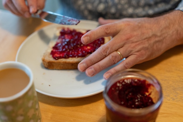 Photo man spread jelly on his bread