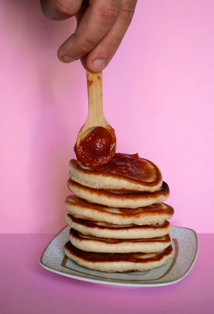 Foto un uomo sparge marmellata sulle frittelle