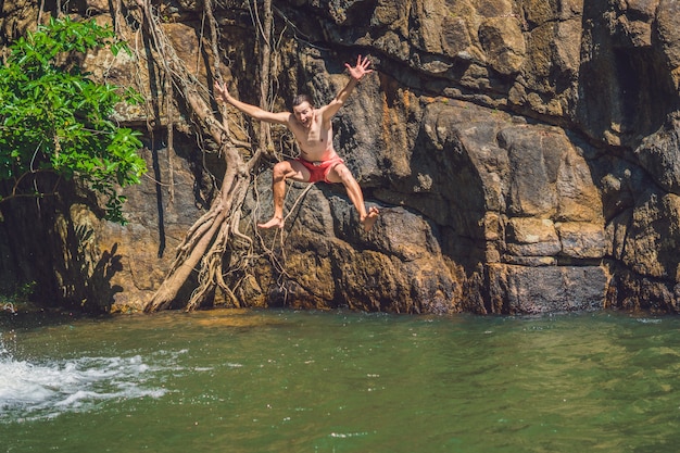 Man springen van klif in het water