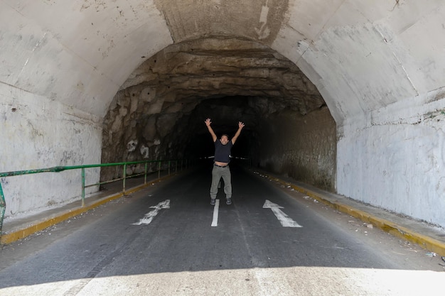 Man springt gelukkig in een tunnel en een weg.