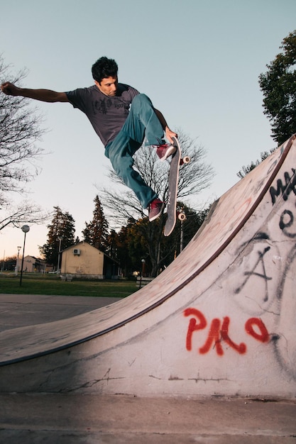 Man springt op skateboard tegen de hemel