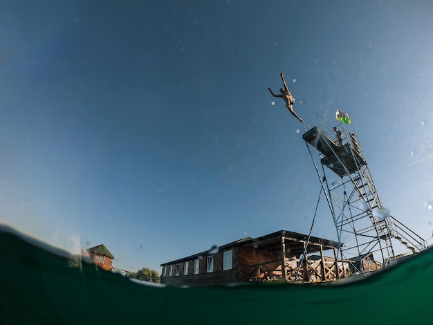 Man springt van toren naar meerwater