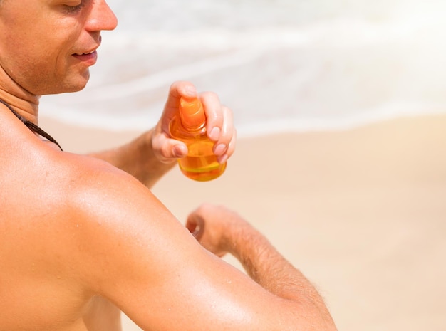 Man sproeien zonnebrandcrème op de huid