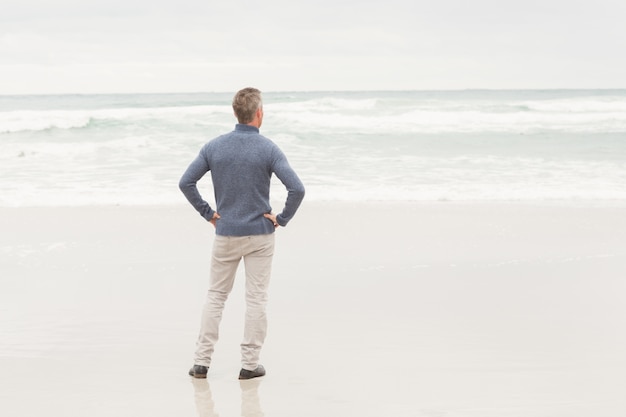 Man staat aan de rand van de zee